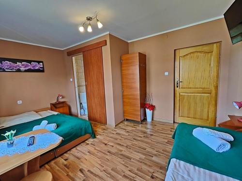 a bedroom with two beds and a wooden floor at Pokoje Gościnne Łukaszczyk in Białka Tatrzanska