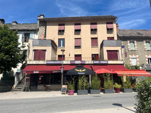 un grand bâtiment avec un auvent rouge dans une rue dans l'établissement Urbain V, à Le Monastier