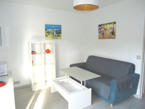 un salon avec un canapé bleu et une table dans l'établissement Bel appartement 2 pièces climatisé 500m centre, à Cavalaire-sur-Mer
