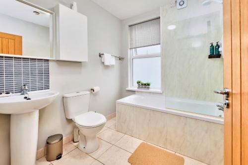 ein Badezimmer mit Toilette, Badewanne und Waschbecken in der Unterkunft Princess Green 5 - Portrush by the Sea in Portrush