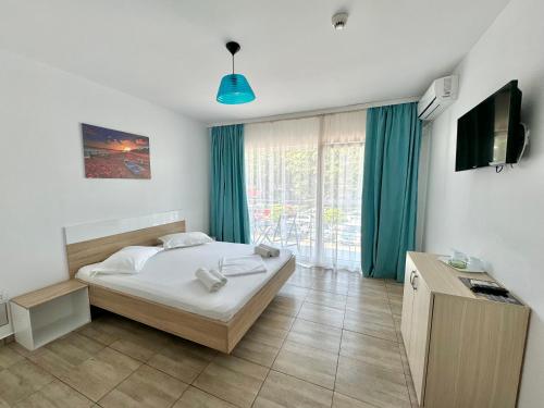 une chambre avec un lit et une télévision dans l'établissement Vila Maria, à Eforie Nord