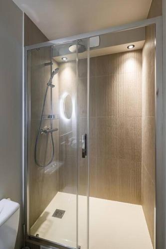 une douche avec une porte vitrée dans une salle de bain dans l'établissement Bali Lake - Duke Housing, à Créteil