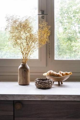 un comptoir avec un vase et un bol sur une fenêtre dans l'établissement Bali Lake - Duke Housing, à Créteil