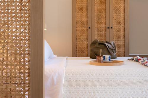 a bed with a table with a candle on it at Nisomar Suites in Symi