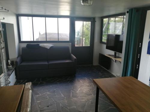 un salon avec un canapé et une télévision dans l'établissement Le Moka, à Auray