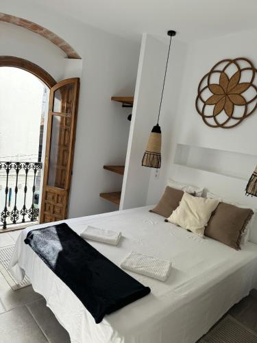 a white bed in a room with a window at Apartamento Café Bernal in Tarifa
