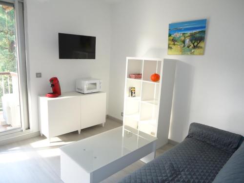 un salon blanc avec une table et un canapé dans l'établissement Bel appartement 2 pièces climatisé 500m centre, à Cavalaire-sur-Mer