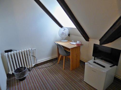 a small room with a desk and a tv and a computer at Hotel Svornost in Prague