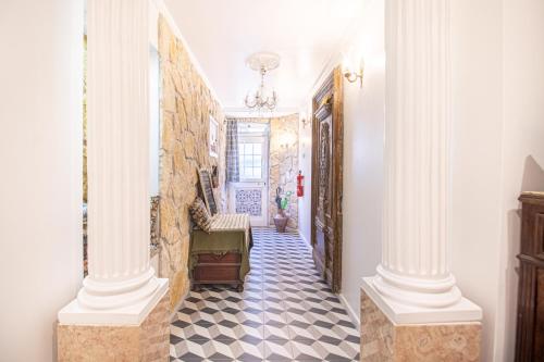 a hallway with white columns and a checkered floor at Fernando Lemos Estúdio Lisboa in Lisbon