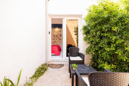 a patio with a table and chairs and a bush at Affittacamere Casa Concia in Tortolì