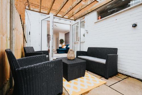 a patio with wicker chairs and a table at Cheshire Retreat, close to Tatton Park in Knutsford