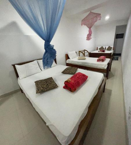 two beds in a room with red sheets at Viyanga Homestay in Ella