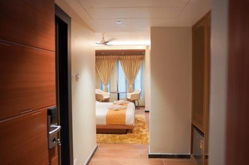 a bedroom with a bed and a room with a bed and curtains at Hotel Beyond Blu,Port Blair in Port Blair