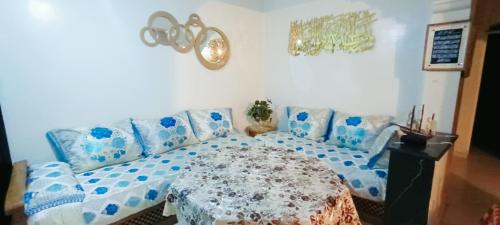un soggiorno con un divano blu e un tavolo di Rez-de-jardin à 5 min de la plage d'Agadir ad Agadir