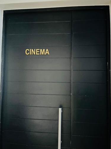 a black garage door with the word cinema on it at 12 Elizabeth Place - Beautiful self catering 2 bedroom unit next to Kyalami Racetrack with free WiFi - swimming pool gym and restaurant - Perfect for a small family in Midrand Waterfall in Midrand
