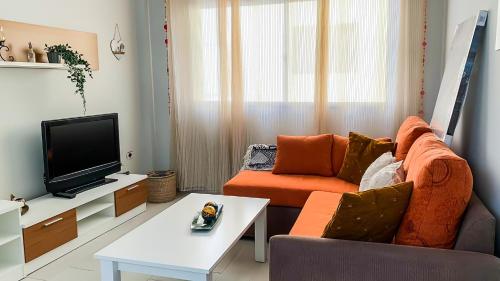 ein Wohnzimmer mit Sofa und Fernseher in der Unterkunft Beachhouse Gran Tarajal 3BR in Gran Tarajal
