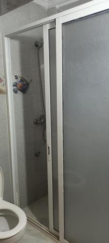 a shower with a glass door in a bathroom at Grand Appt près de la mer in Hajreien