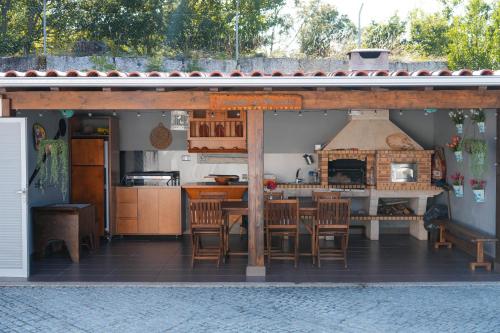 a kitchen with a table and a pizza oven at Ermal Village in Vieira do Minho