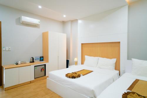 a hotel room with two beds and a kitchen at Khách sạn Minh Long in Tuy Hoa