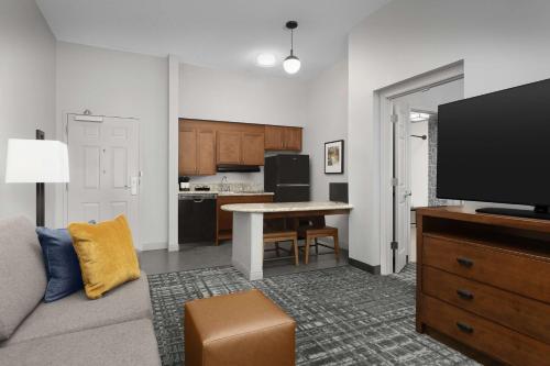 a living room with a couch and a flat screen tv at Homewood Suites by Hilton Raleigh-Durham Airport at RTP in Durham