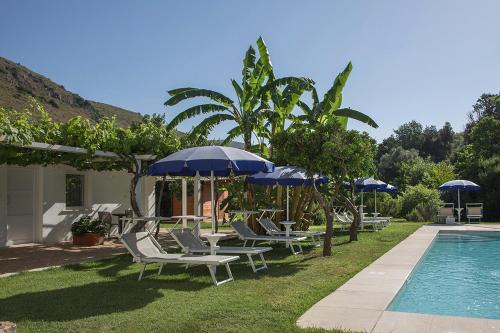 a group of lounge chairs and umbrellas next to a pool at Primavilla Relais in Gaeta