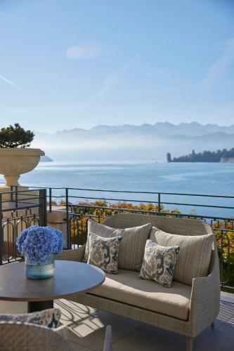 a couch sitting on a balcony with a table at Mandarin Oriental Palace, Luzern in Lucerne