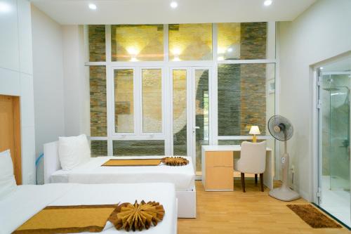 a living room with two beds and a window at Khách sạn Minh Long in Tuy Hoa