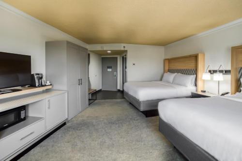 a hotel room with two beds and a flat screen tv at Holiday Inn Mobile Downtown Historic District by IHG in Mobile