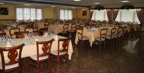 a banquet hall with tables and chairs with glasses on them at Hotel Rausan in Alfajar&iacute;n