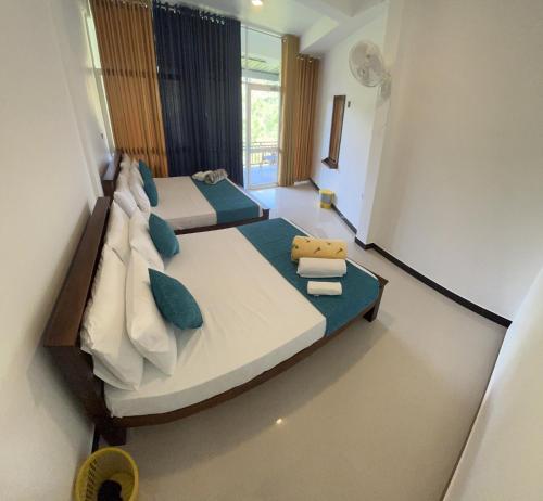 a bedroom with two beds and a teddy bear sitting on top at Viyanga Homestay in Ella