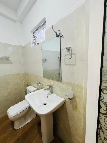 a bathroom with a sink and a toilet and a mirror at Viyanga Homestay in Ella
