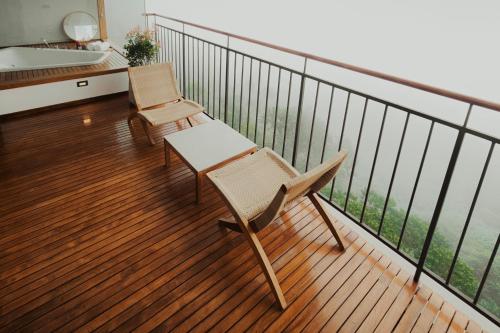 a balcony with two chairs and a sink at The Valle by Kondody Hotels in Munnar