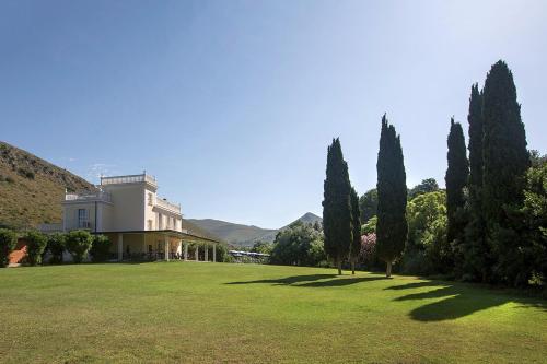 a large yard with trees and a house at Primavilla Relais in Gaeta
