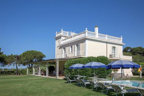 a large white house with a pool and chairs and umbrellas at Primavilla Relais in Gaeta