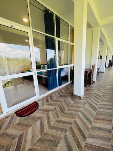 an empty lobby with a wooden floor and windows at Viyanga Homestay in Ella