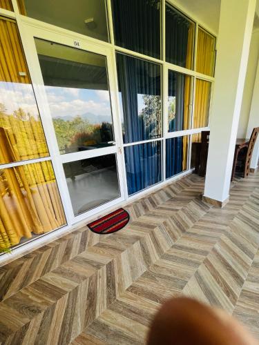 a room with large windows and a wooden floor at Viyanga Homestay in Ella