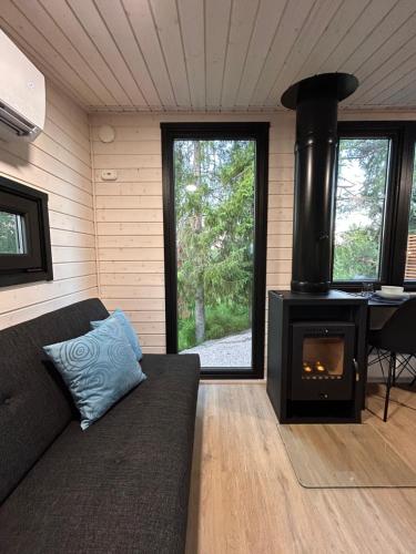 a living room with a couch and a stove at The Saunacabin Enchanted Lapland in Rovaniemi