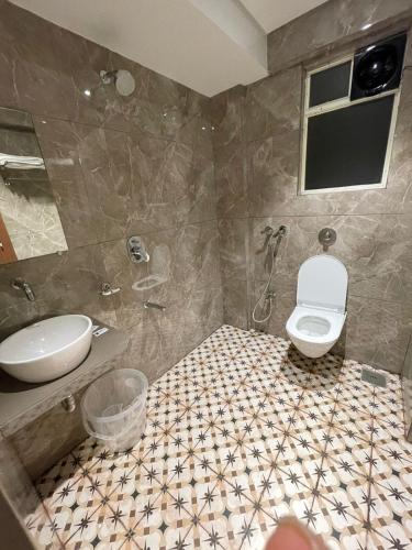 a bathroom with a toilet and a sink at Hotel The West Coast in Vasai