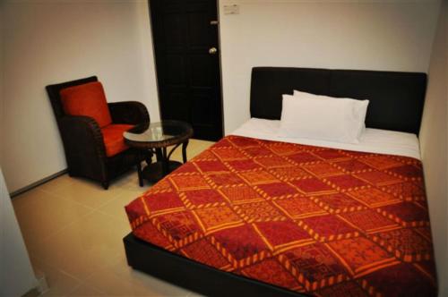 1 dormitorio con 1 cama, 1 silla y 1 mesa en Old Budget Hotel en George Town