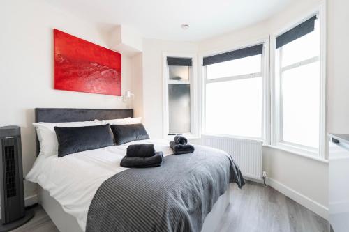 a bedroom with a large white bed with two windows at Boutique Studios by Luxestays Fulham Broadway in London