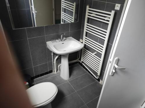 Un baño con un lavabo blanco y un inodoro. en Alliances & Missions Médicales, en Versalles