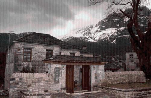 an old stone house in front of a mountain at Archontiko Geki 1876 in Papigko