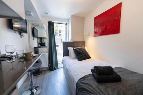 a bedroom with two beds and a desk in it at Boutique Studios by Luxestays Fulham Broadway in London