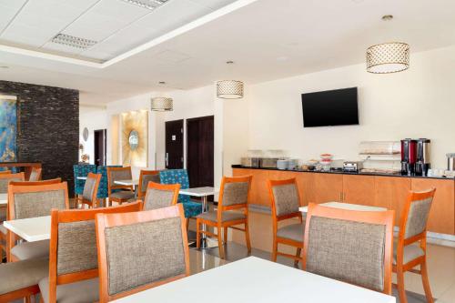a restaurant with tables and chairs and a bar at Sleep Inn Monterrey San Pedro in Monterrey