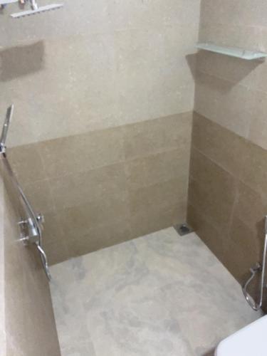 a bathroom with a shower with a tile floor at Viyanga Homestay in Ella