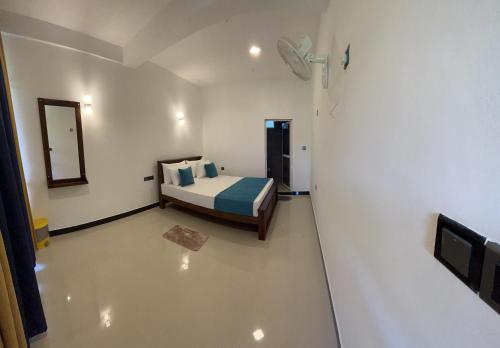 a bedroom with a bed and a mirror on the wall at Viyanga Homestay in Ella