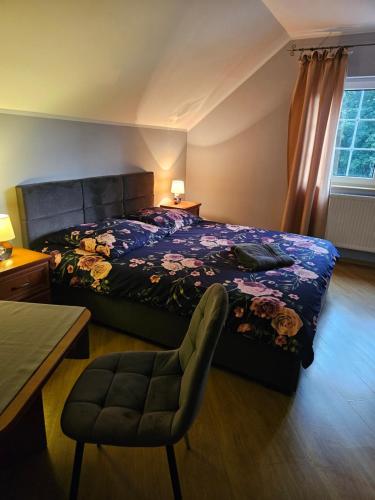 a bedroom with a bed and a chair at DOMKI w Zaciszu in Ruś