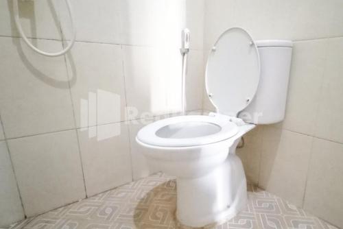 La salle de bains est pourvue d'une douche et de toilettes blanches. dans l'établissement Almeira Homestay Syariah Near RS Islam Al-Irsyad Mitra Reddoorz, à Surabaya