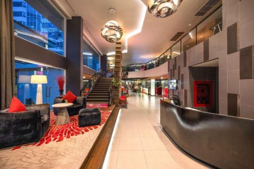 a lobby with couches and chairs in a building at Park Plaza Bangkok Soi 18 in Bangkok