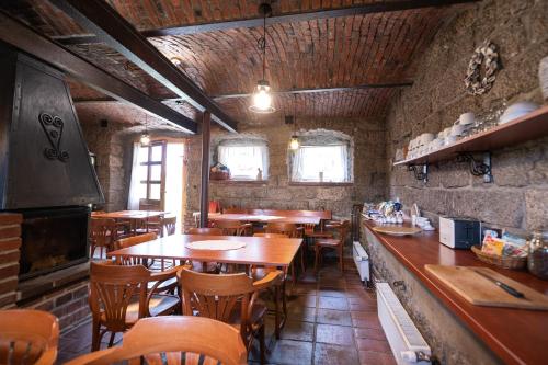 a restaurant with wooden tables and chairs and a bar at Penzion Statek u Rajtrů in Bedřichov
